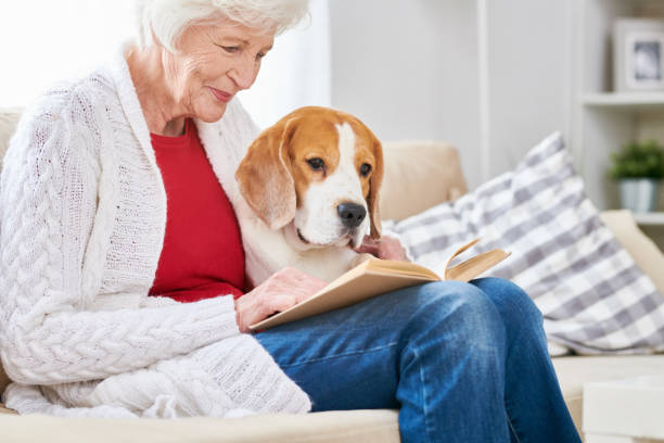 senior woman lite complexion reading to dog