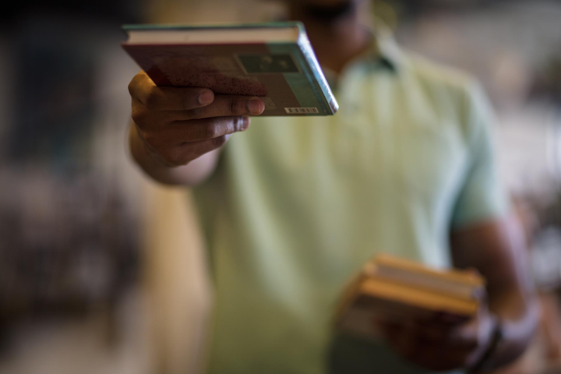 person offering a book to you