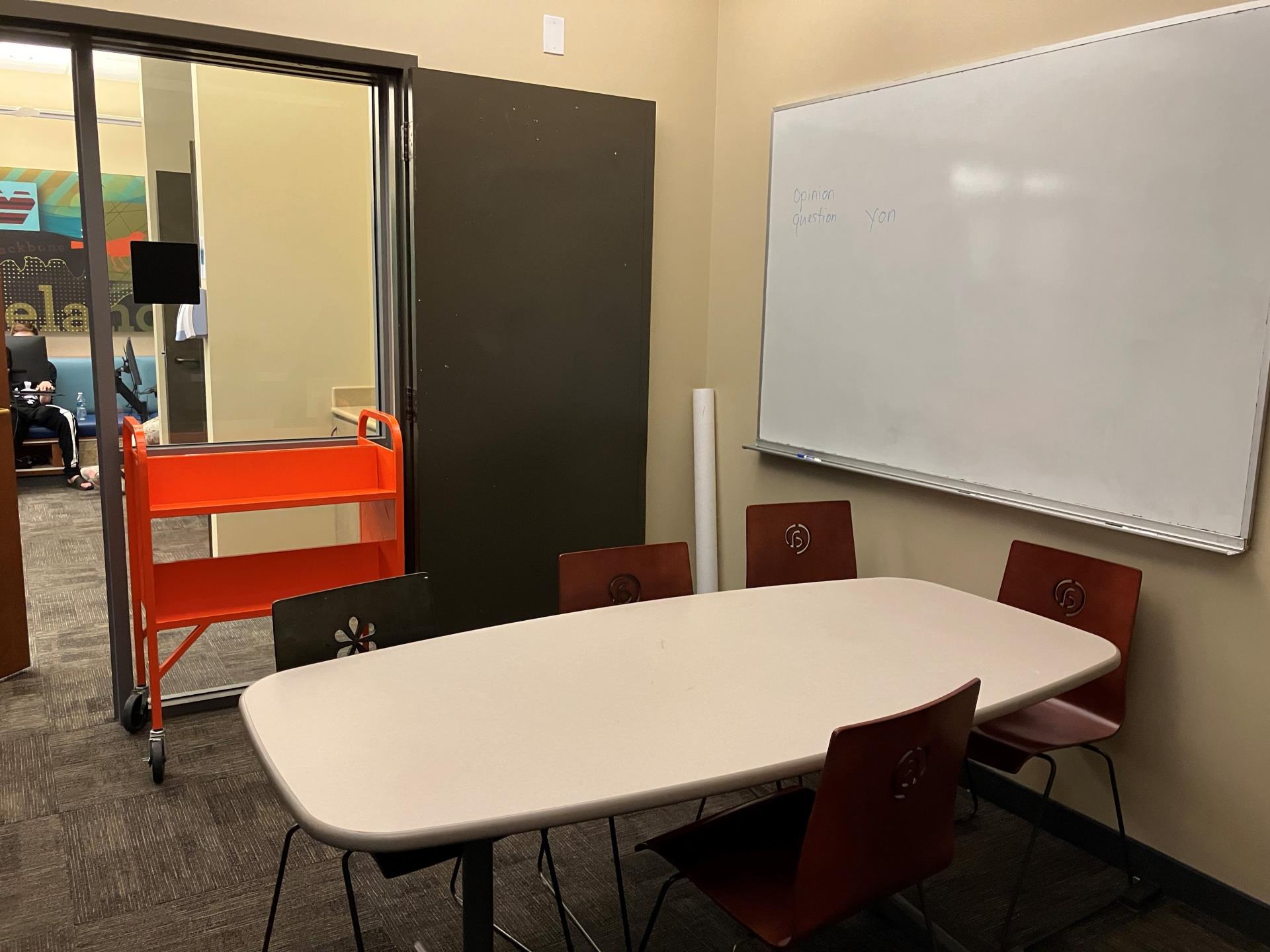 Study room with whiteboard, table, and chairs