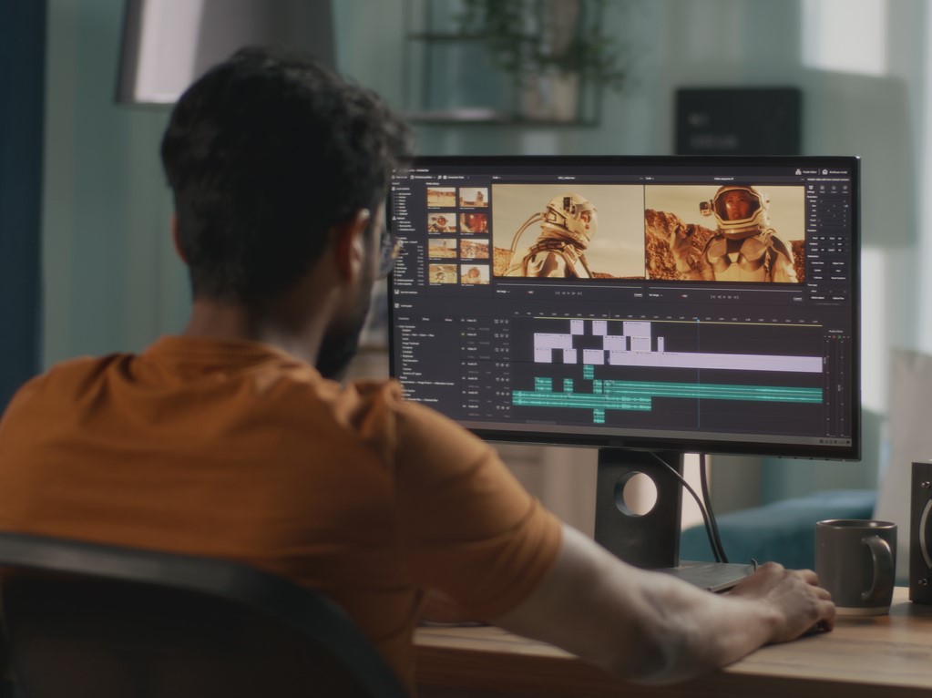 A man using a computer to edit a video