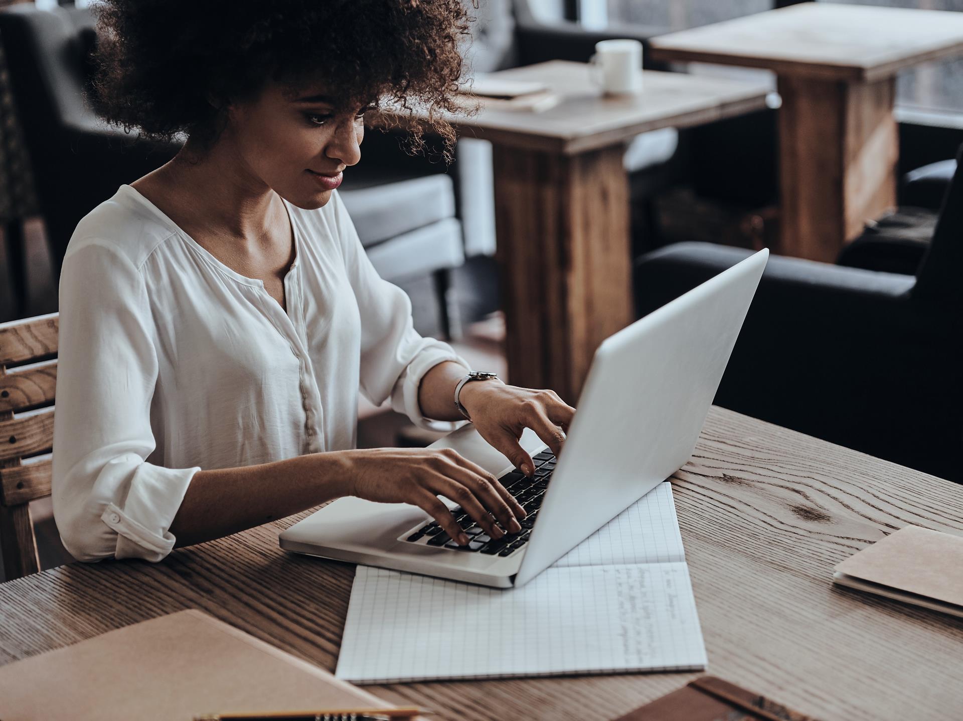 young woman using computer and sitting in cafe