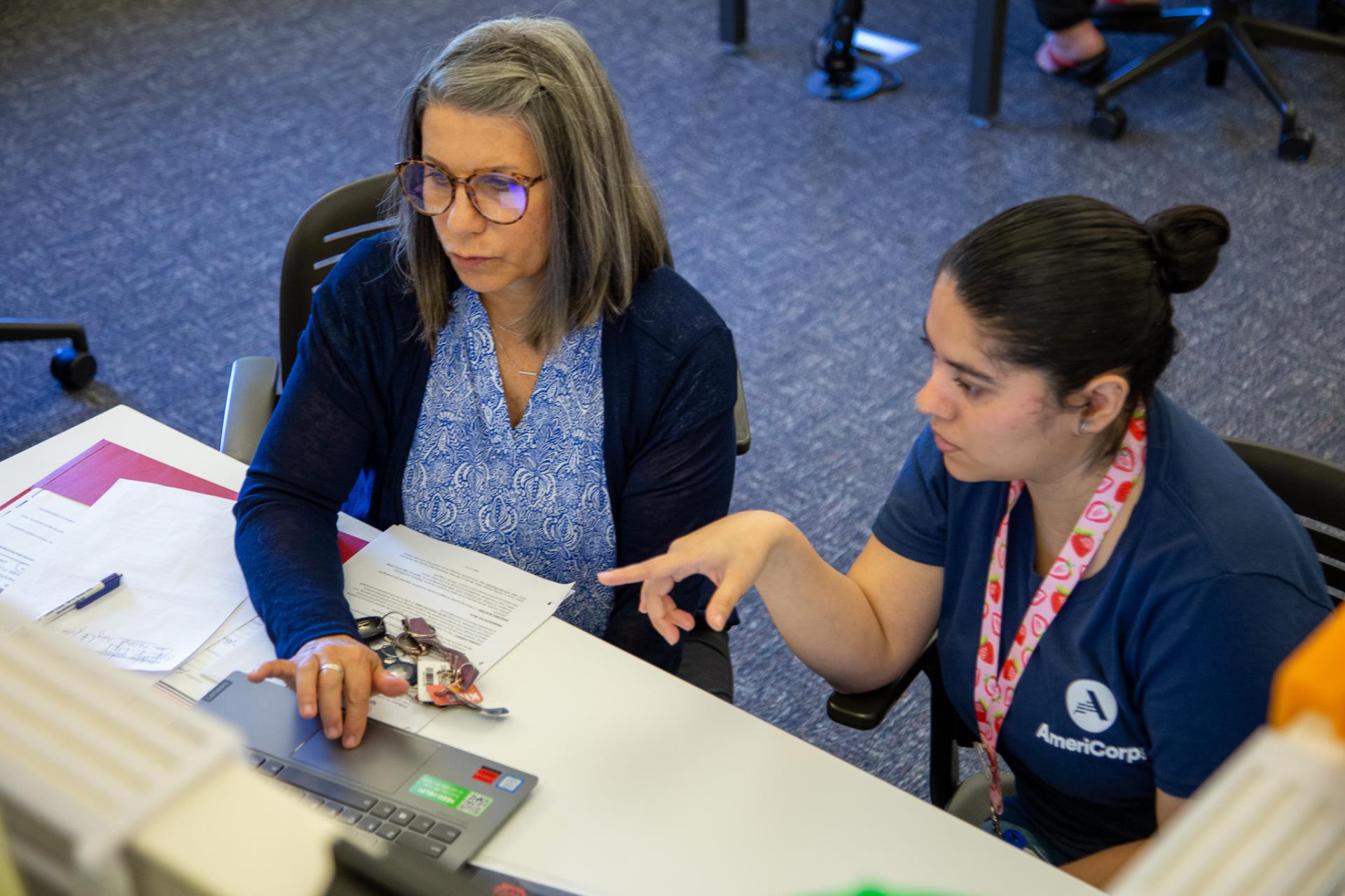 Digital Navigator pointing at the laptop screen and informing learner